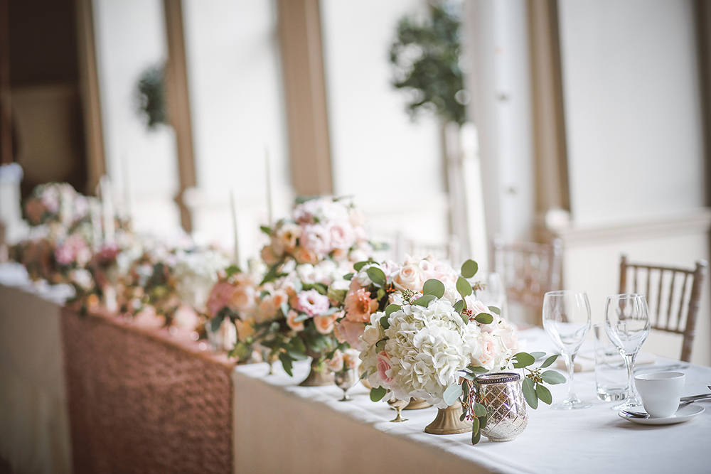 Mesa con ramos de flores y vasija